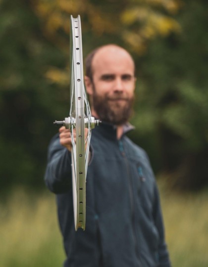 Un homme porte son vélo (visuel Unsplash libre de droits)